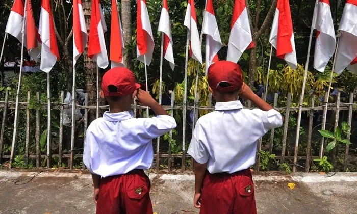 Dua orang anak hormat kepada Bendera Merah Putih seusai mengikuti kirab dan pemasangan