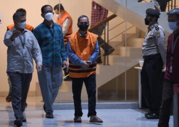 Petugas KPK membawa Rektor Universitas Lampung (Unila) Karomani selaku tersangka untuk dihadirkan dalam konferensi pers hasil kegiatan tangkap tangan di Gedung Merah Putih KPK, Jakarta Selatan, Ahad (21/8/2022).